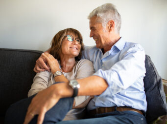 loving older couple sitting on sofa